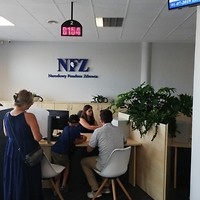 Kolorowa fotografia. Nowy punkt obsługi klienta NFZ w Kielcach. Rodzina oczekuje na wydanie karty EKUZ.