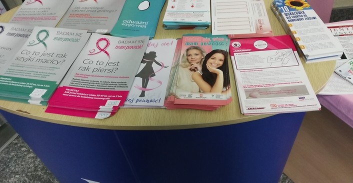 Kolorowa fotografia. Stoisko NFZ z ulotkami na temat profilaktyki raka piersi