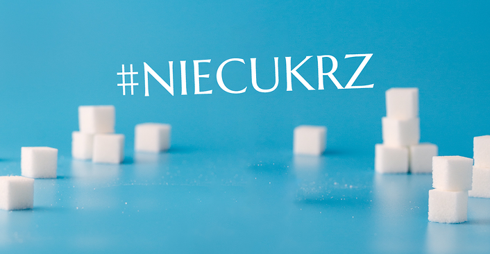 Kolorowa fotografia. Kostki cukru na niebieskim tle oraz napis #NIECUKRZ