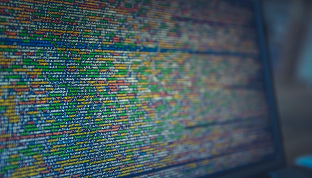 Kolorowa fotografia. Kod programowania widoczny na ekranie laptopa.